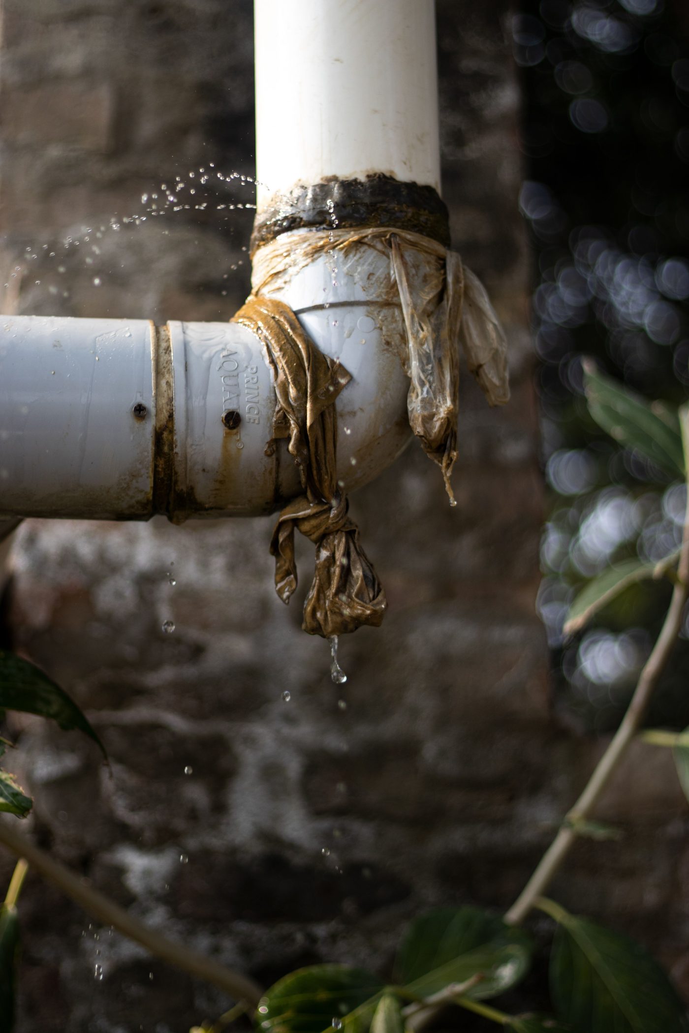Water dripping from a taped, leaking pipe joint